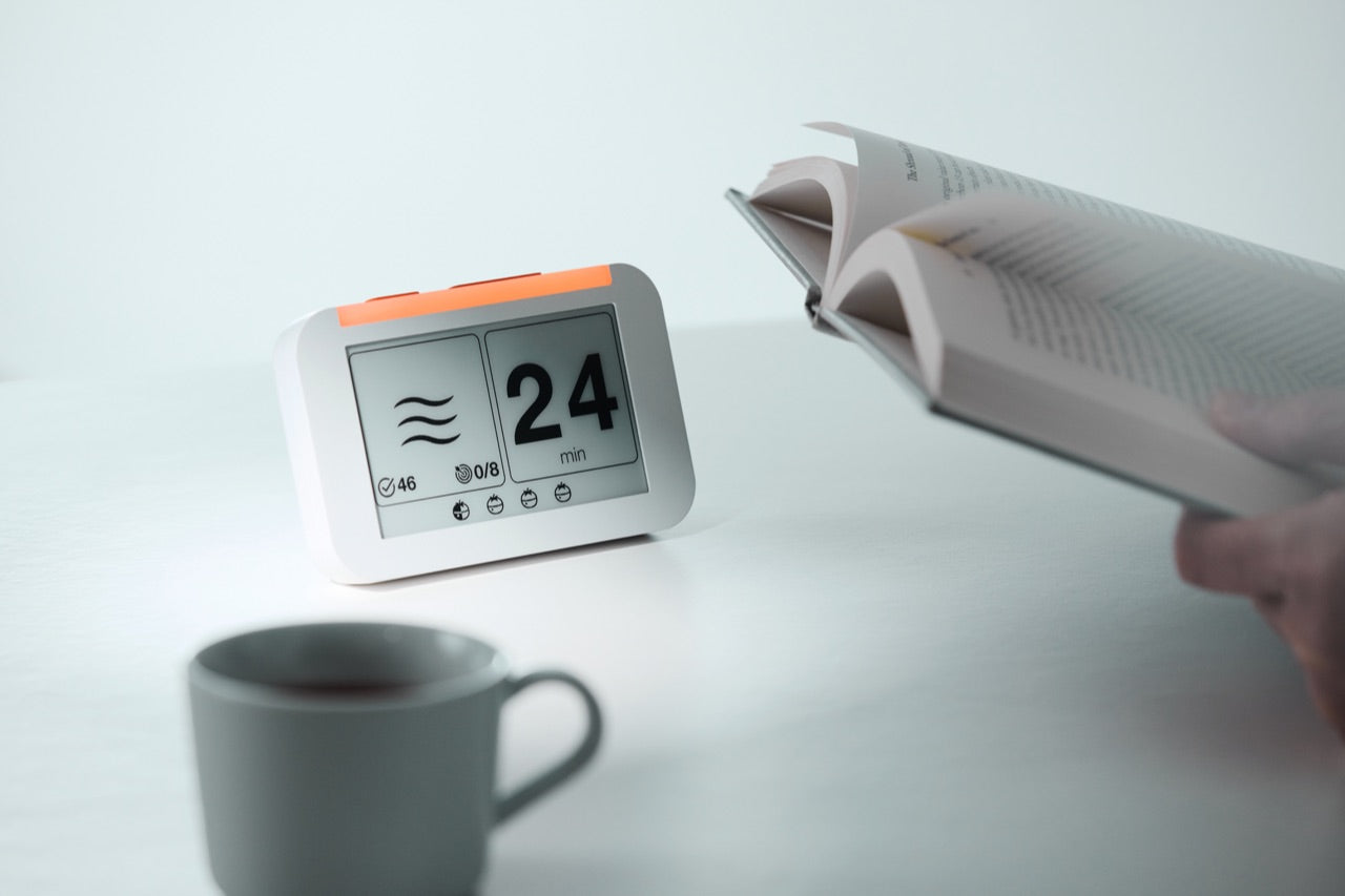 使用者在桌前閱讀，Flow Clock 在桌面陪伴工作